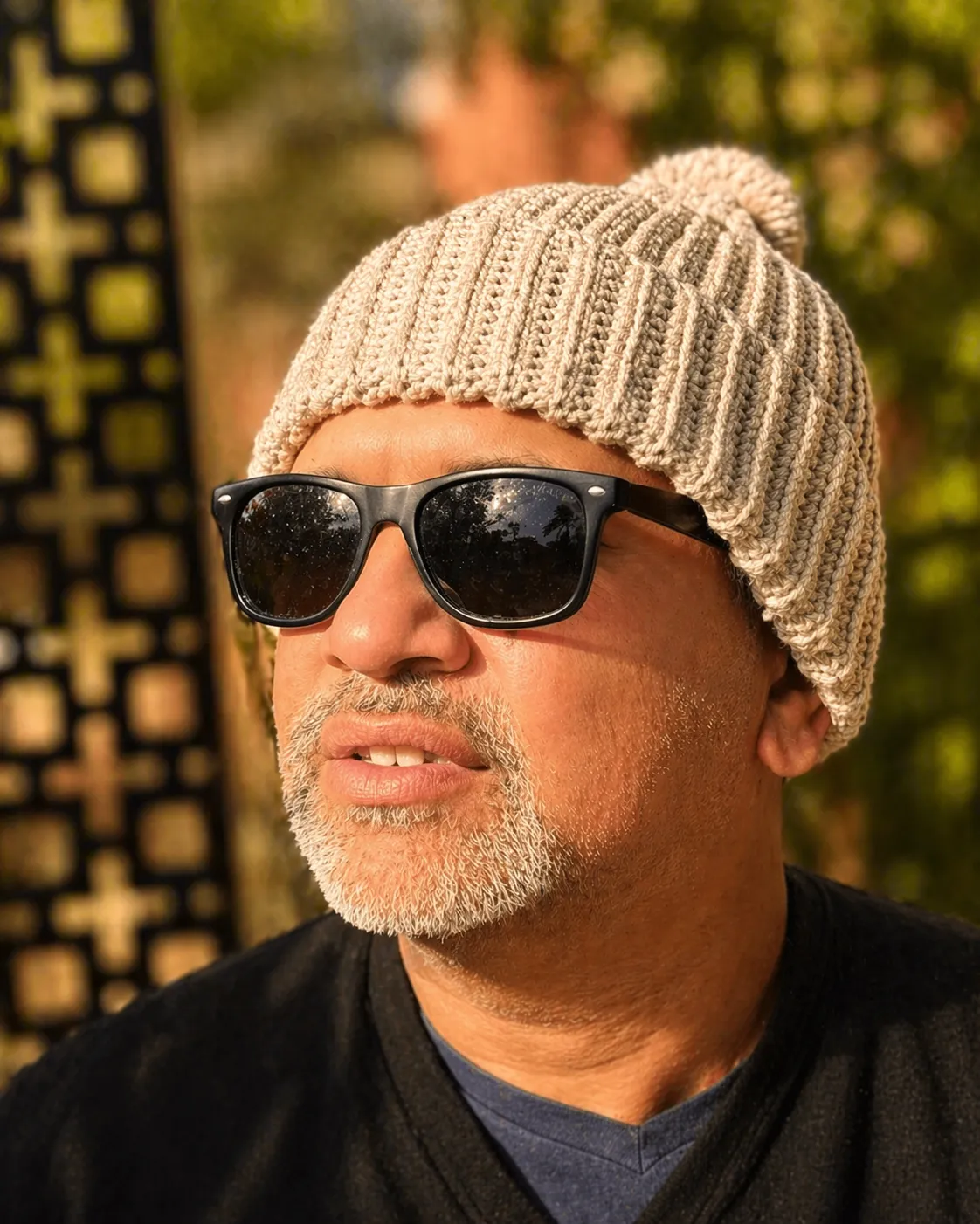 Adult with Oatmeal beanie wearning glasses on a sunny day