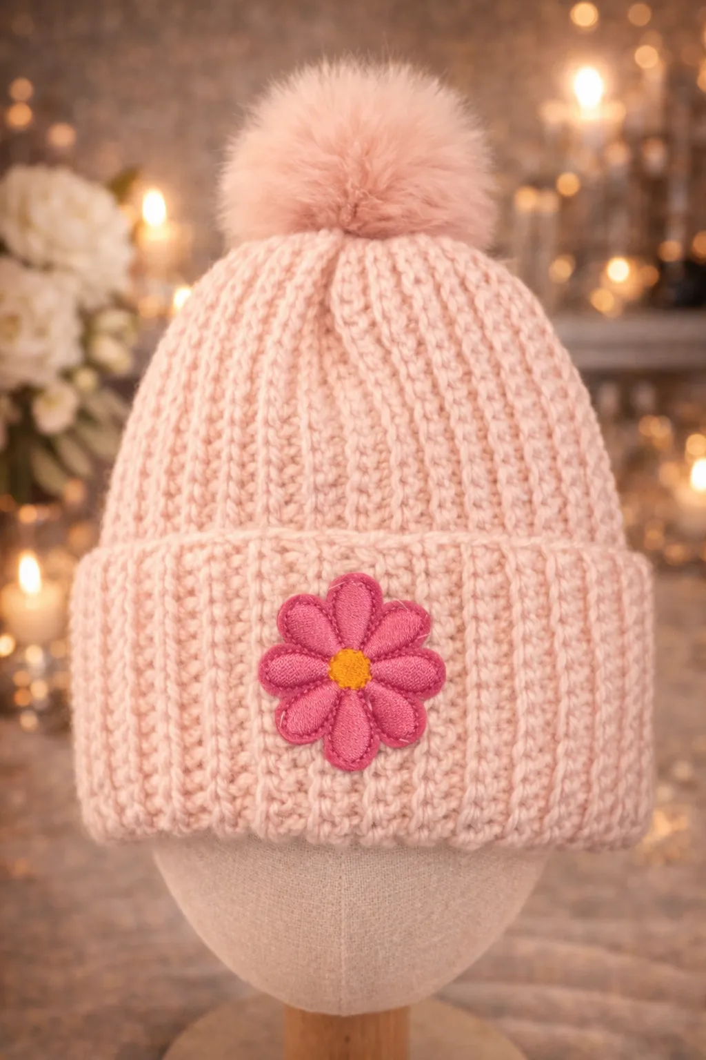 Soft blush ribbed kids beanie with matching pom and hand-stitched pink daisy patch.