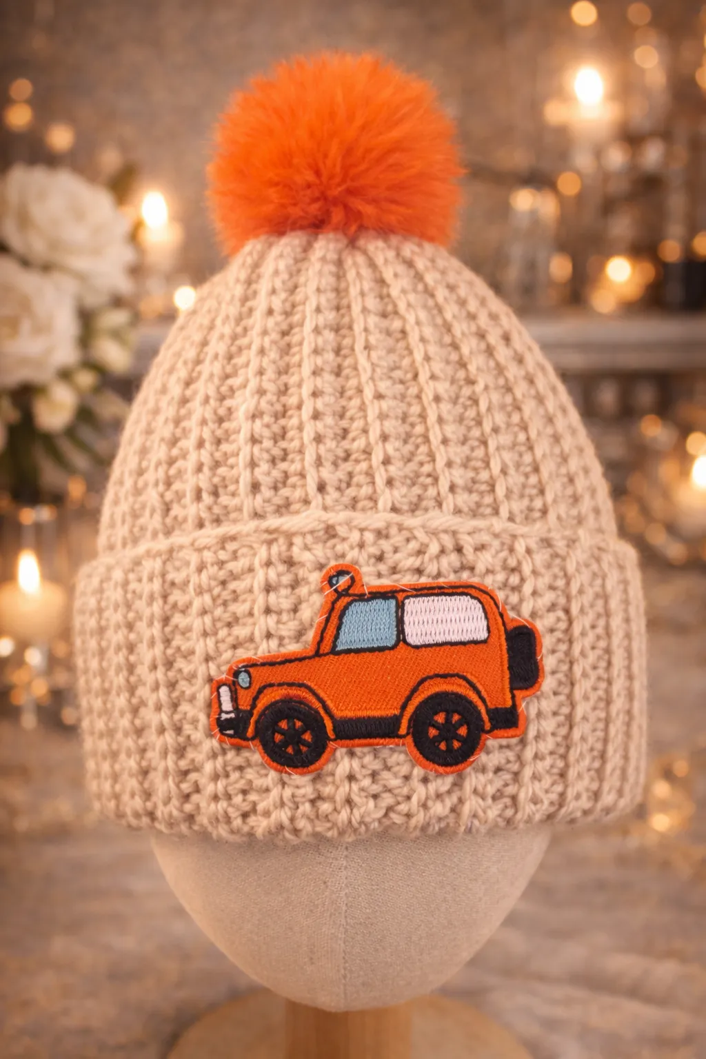 Two kids beanies — an oatmeal one and an orange-truck patterned one — side by side.